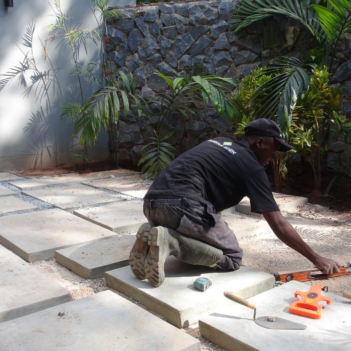 A worker installing stepping stones in a garden